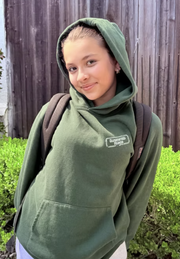 Girl wearing the Guaranteed Human™ crest hoodie