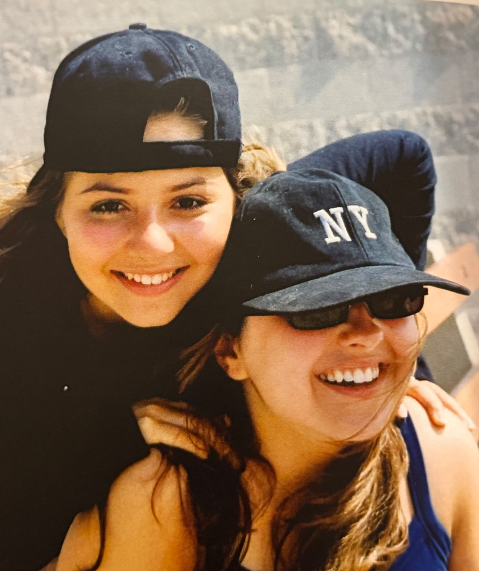 Jen and Karine smiling together in baseball caps, 2001