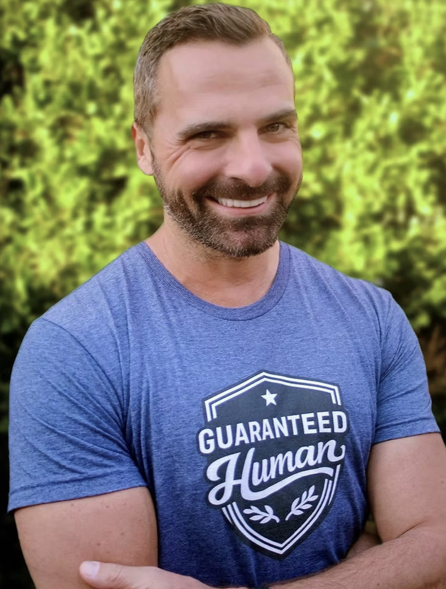 Man wearing the Guaranteed Human™ crest tee