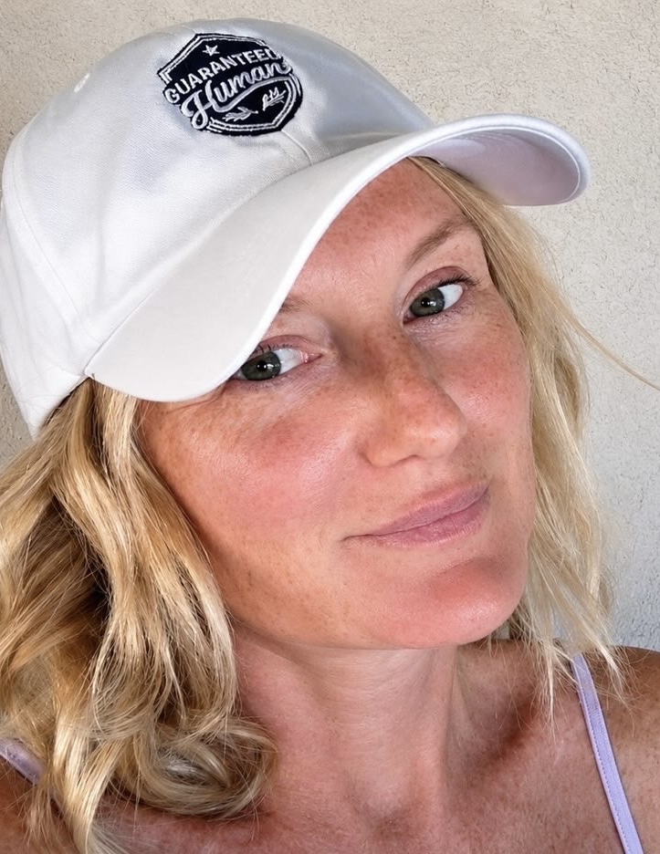 Woman wearing the white Guaranteed Human™ emblem cap